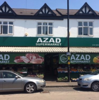 Supermarktfassade des Azad-Supermarkts mit geparkten Autos