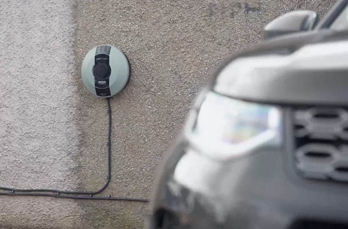Nahaufnahme eines Autos an einer Wand mit Ladestation