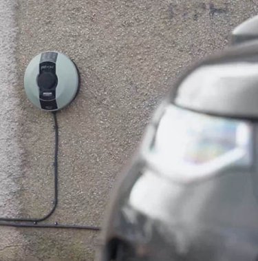 Nahaufnahme eines Autos an einer Wand mit Ladestation